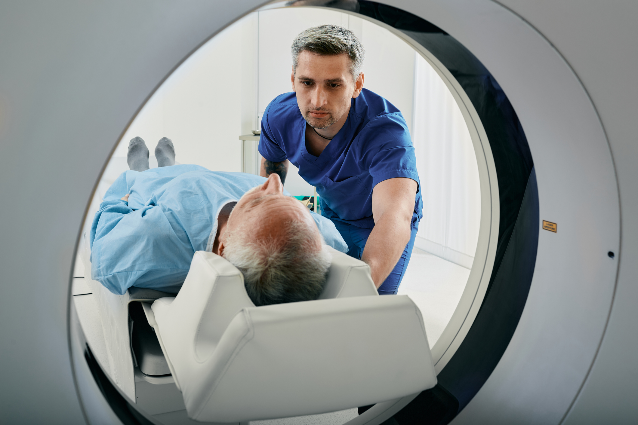 Senior man going into CT scanner.